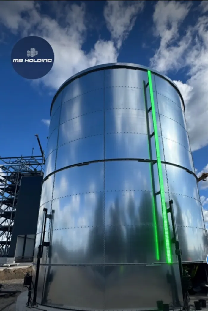 Blue bolted-steel tank with a SHIELD green LED level bar at dusk