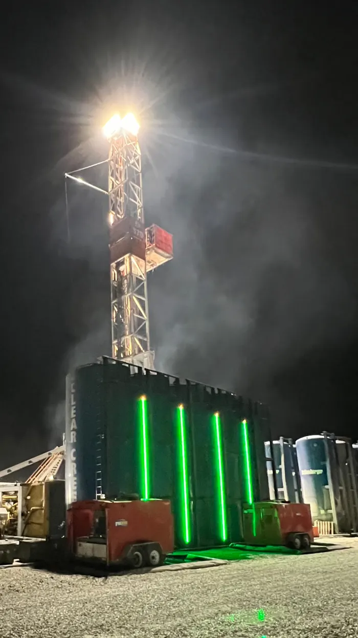 Storage tanks with SHIELD green LED level bars under a dramatic sky