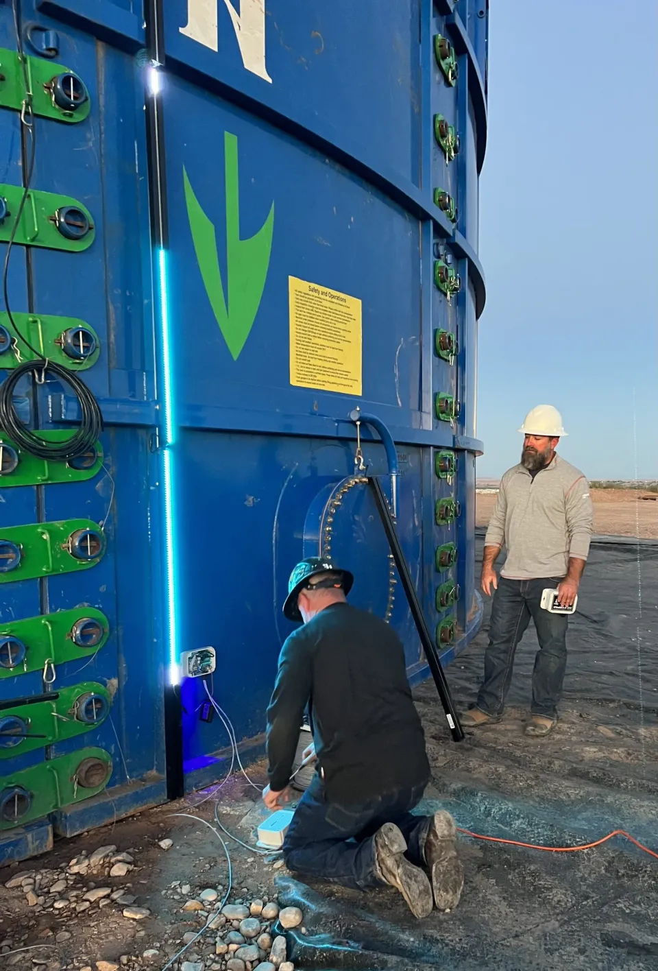 DCon technicians installing a SHIELD LED level monitoring system on a tank
